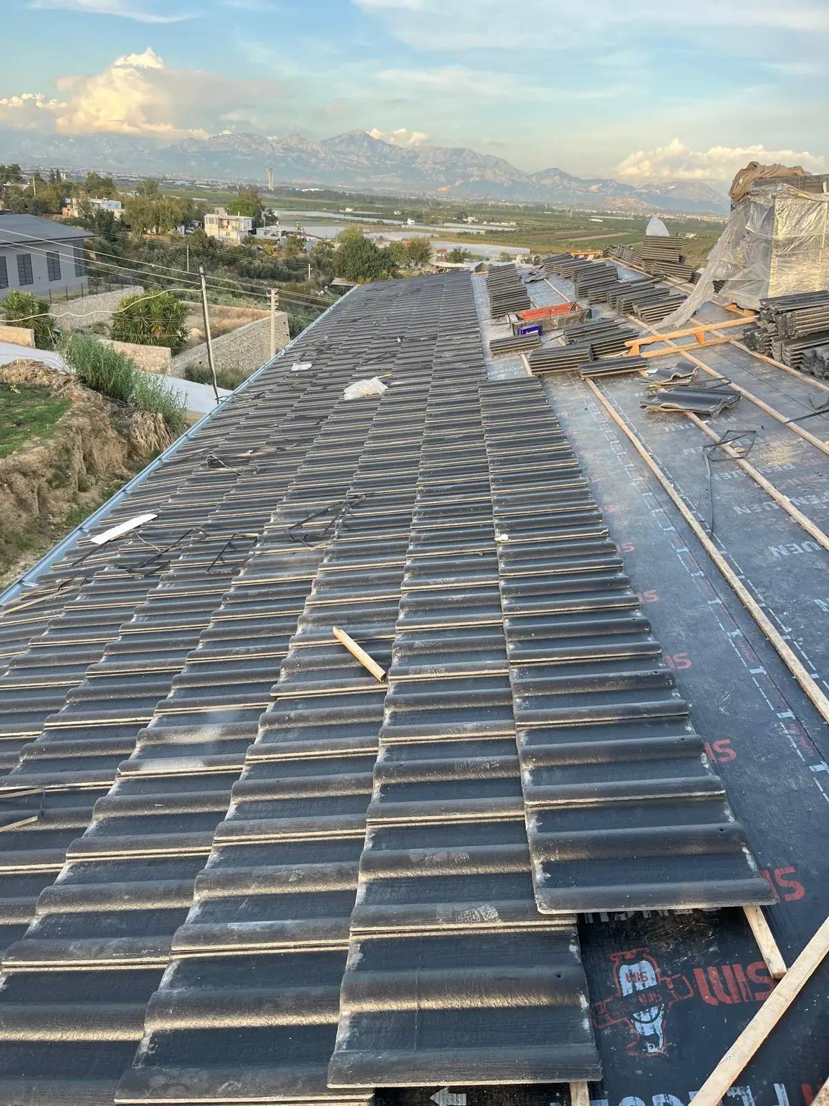Tiles laid over membrane and battens, with the Taurus Mountains behind.