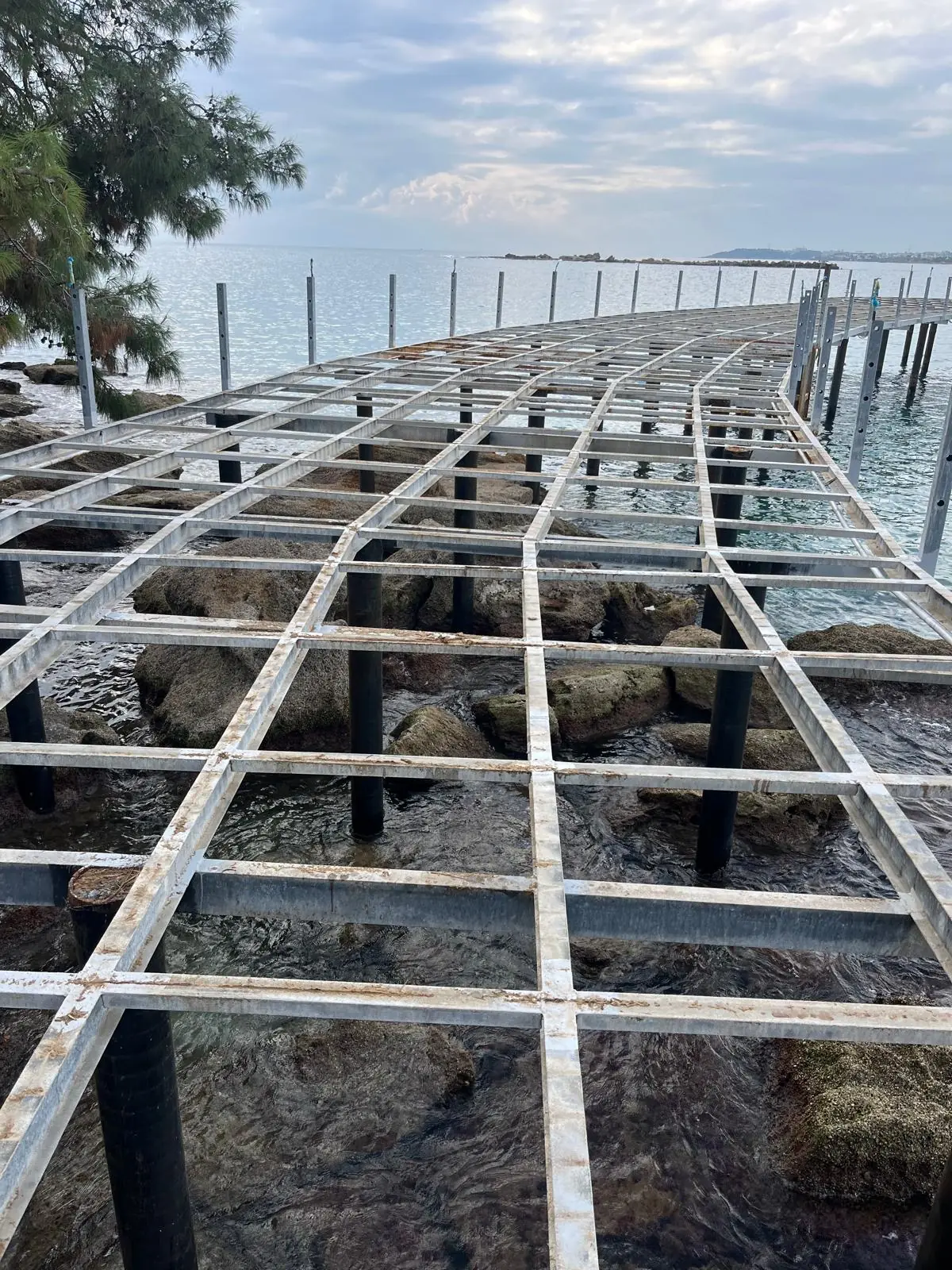 Steel pier grid on piles over the sea.