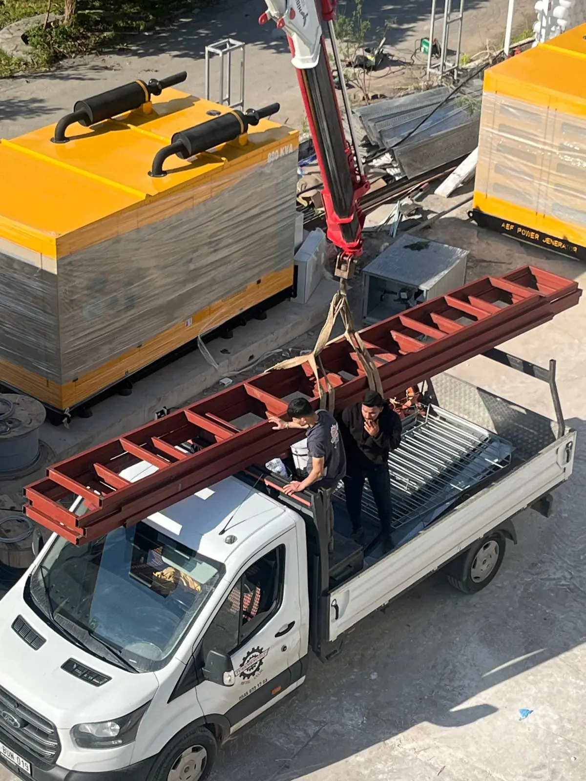A red-primed steel stair stringer on a pickup, generators behind.